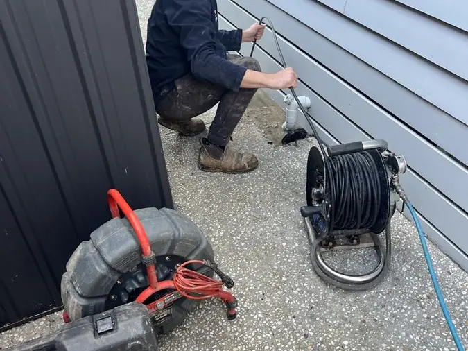 Drain inspection equipment beside a plumber, Braeside