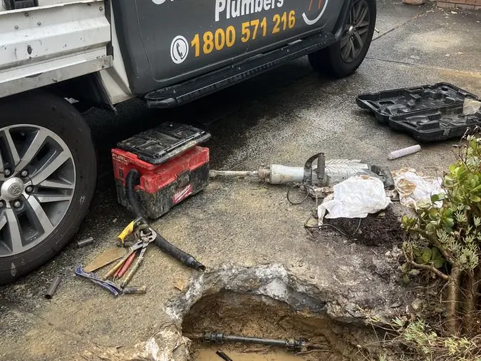 Drain repair equipment beside an open trench, Braeside