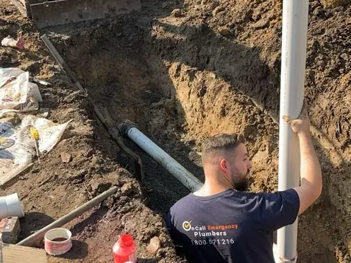 Plumber renewing underground drainage, Braeside